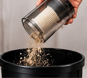 Emptying the transparent dust container into a bin